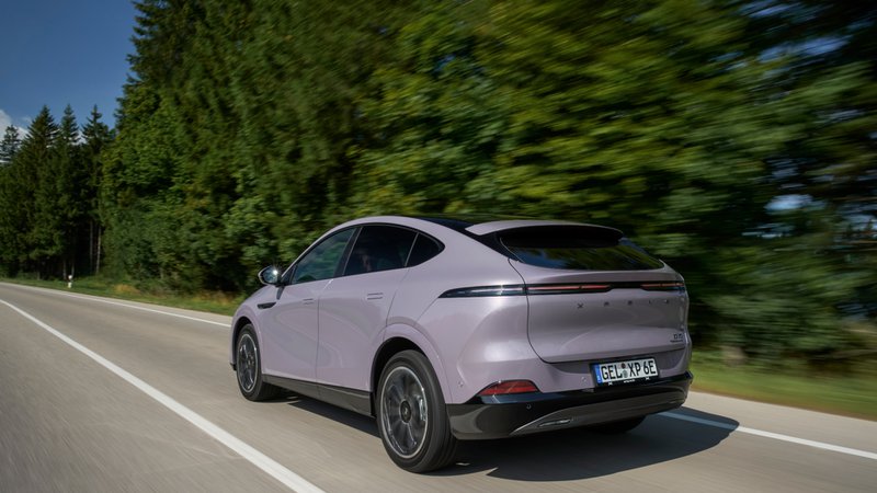 Xpeng G6 vue de 3/4 arrière sur une route boisée