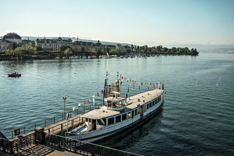 een klein passagiersschip aan de kade van het Meer van Zürich