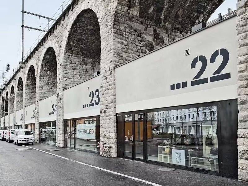 strakke winkelgevels met grote huisnummers onder oude spoorbogen - Zürich